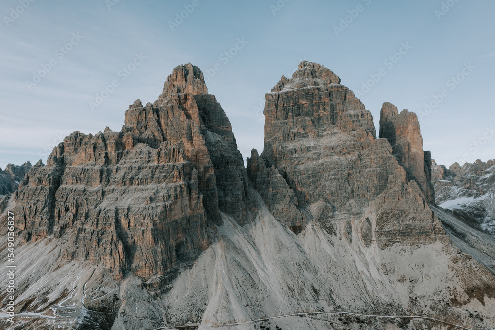 Zwei Personen in roten Jacken vor den drei Zinnen in den Dolomiten. Wandern Tre Cime. Letzte Sonnenstrahlen in den Bergen 1