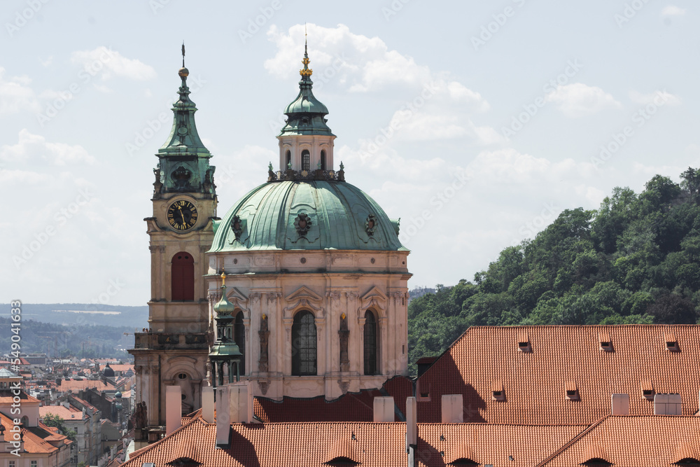 Obraz premium Old Saint Nicholas church with clock tower in Prague, Czech Republic. Cityscape view of Prague old town, high view point