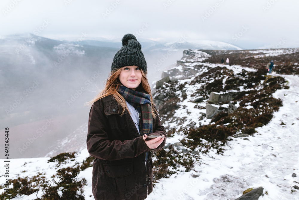 Woman in winter clothes on a snowy hill