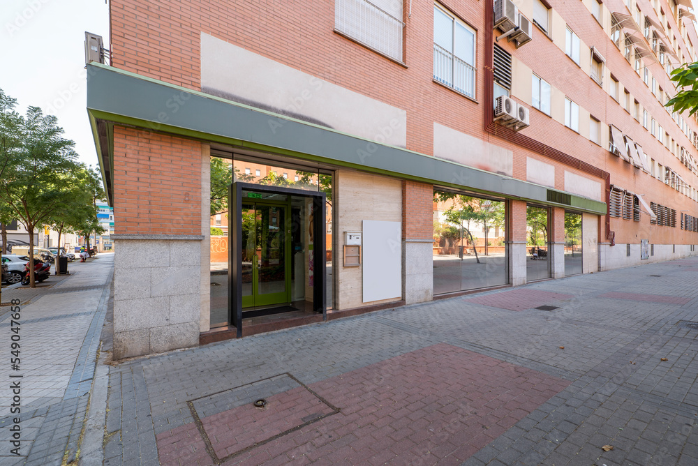 Fototapeta premium Facade of an urban residential housing building with an elongated commercial premises with glass partitions