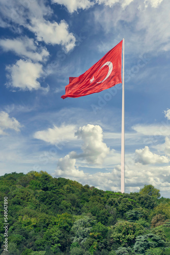 Huge Turkish flag at the mountains of Bosphorus strait, in a cloudy sunny summer day, Istanbul, Turkey