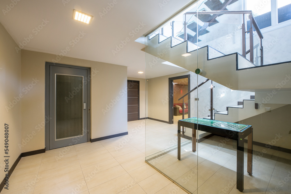 Interior of a single-family home staircase with stoneware floors, a metal design staircase with tempered glass steps and a structure with glass partitions Interior of a single-family home staircase with stoneware floors, a metal design staircase with tempered glass steps and a structure with glass partitions
