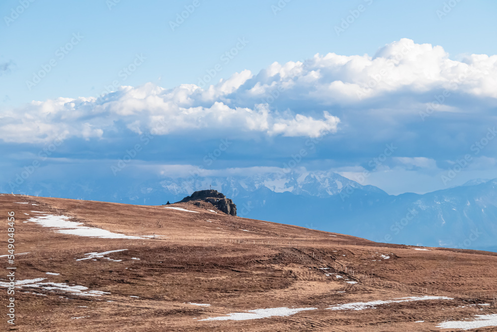 Scenic morning view after sunrise on summit cross of mountain peak Grosser Sauofen, Saualpe, Lavanttal Alps, Carinthia, Austria, Europe. Hiking trail in Wolfsberg. Karawanks mountains in the back