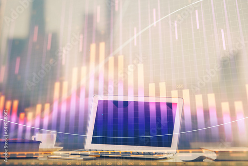 Forex graph hologram on table with computer background. Multi exposure. Concept of financial markets.