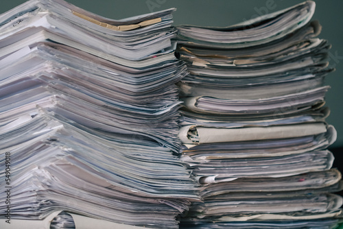 Stack of blank papers with binder clips on wooden table indoors. Workplace. Many documents, contracts, legal agreements, papers on work table. Concept of business, working, job