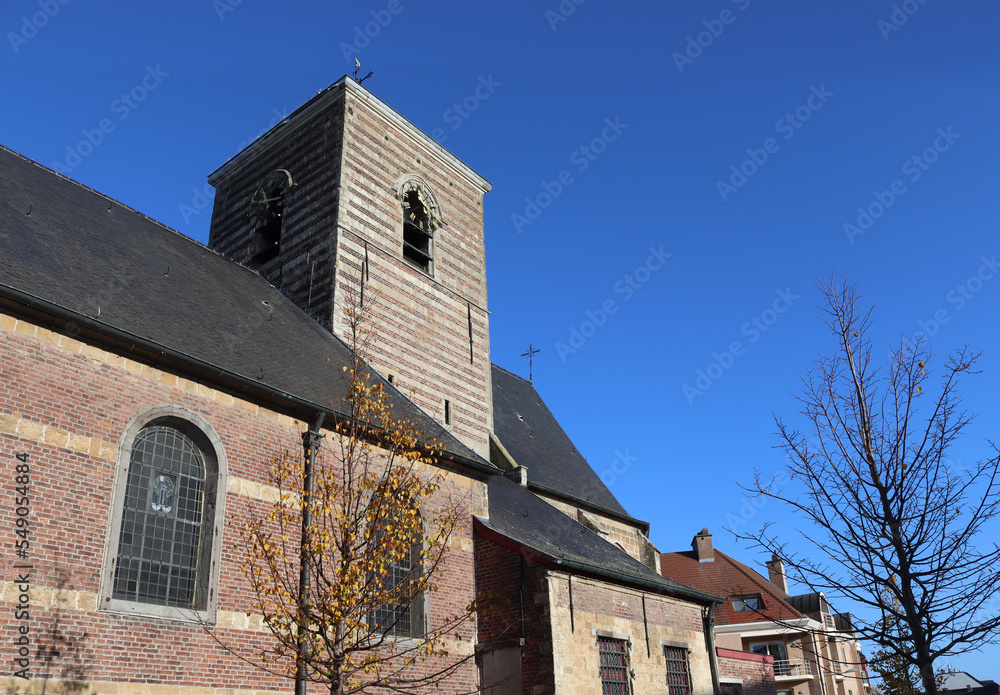 View of the historic Our Lady's parish church in Nieuwerkerken near Aalst in East Flanders, Belgium. Sunny autumn day with clear sky, and copy space above right. View of the historic Our Lady's parish church in Nieuwerkerken near Aalst in East Flanders, Belgium. Sunny autumn day with clear sky, and copy space above right.