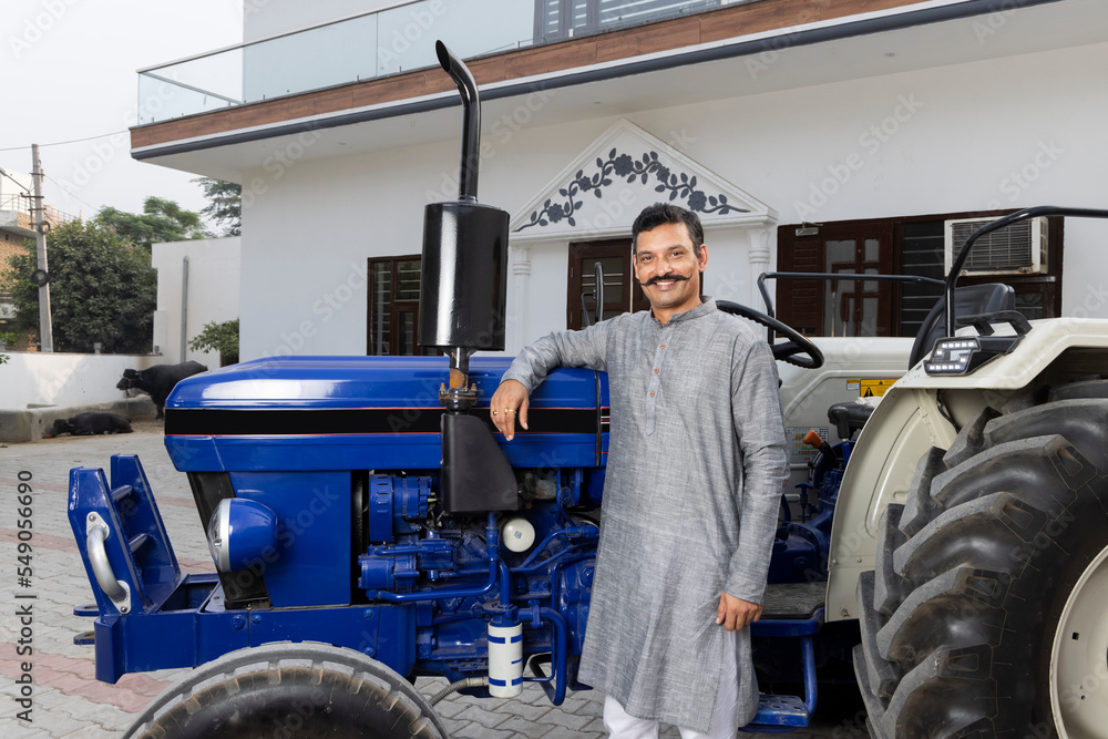 Farmer standing with Tractor at village home. Farmer standing with Tractor at village home.