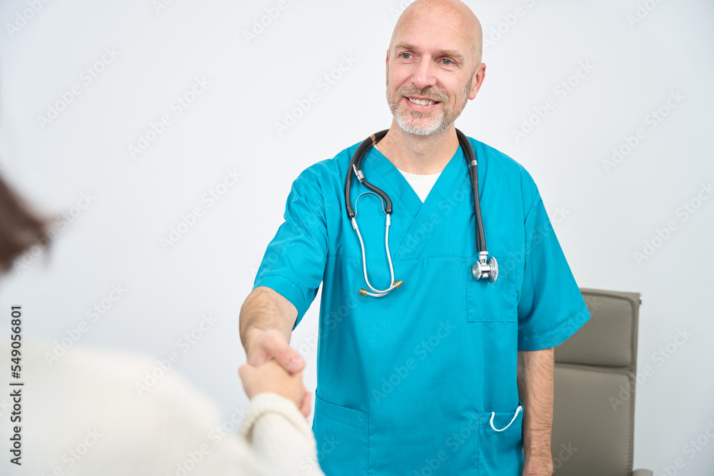Doctor extends hand to the woman opposite in the cabinet Doctor extends hand to the woman opposite in the cabinet