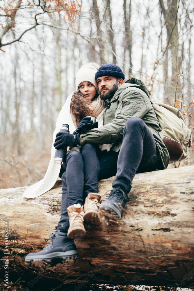 Couple trekking in winter drink hot tea from thermos Couple trekking in winter drink hot tea from thermos