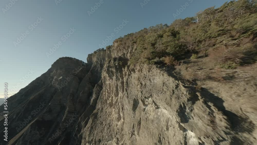 Fly over close to the cliff of the La Viste massif with the clear and sunny blue sky. Fly over close to the cliff of the La Viste massif with the clear and sunny blue sky.