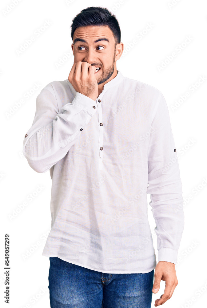 Young handsome man wearing casual clothes looking stressed and nervous with hands on mouth biting nails. anxiety problem. Young handsome man wearing casual clothes looking stressed and nervous with hands on mouth biting nails. anxiety problem.