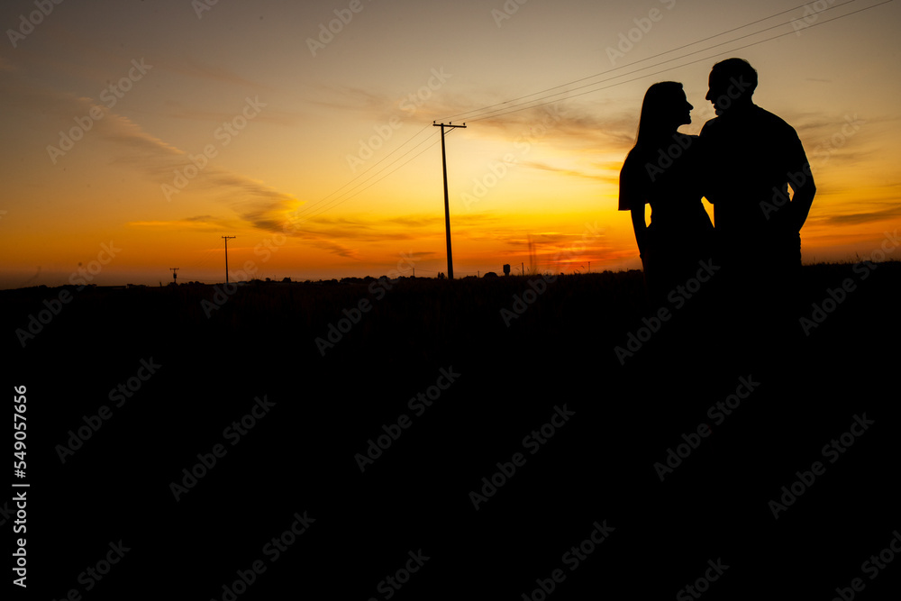 SILHOUETTE OF COUPLE DATING AT SUNSET 