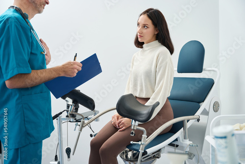 Woman sits on medical chair and listens to a doctor