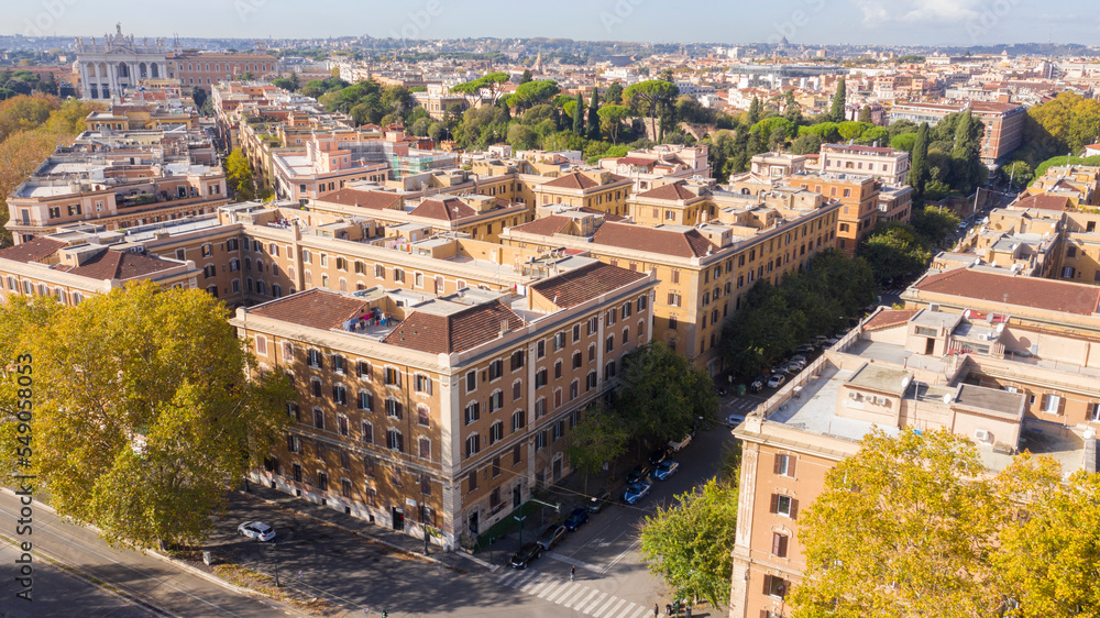 Fototapeta premium Aerial view of a group of buildings. In background the Papal Archbasilica of Saint John Lateran, also referred to as the Cathedral of city.
