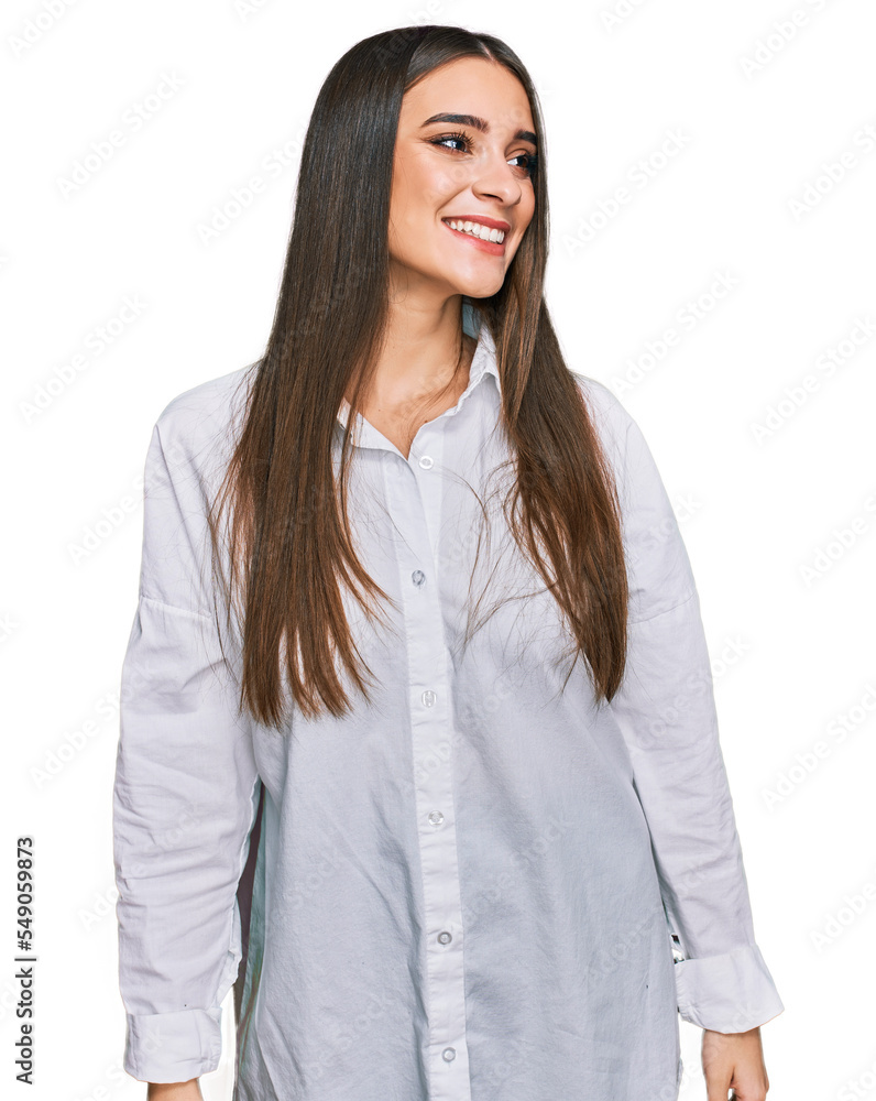 Young beautiful woman wearing casual white shirt looking away to side with smile on face, natural expression. laughing confident. Young beautiful woman wearing casual white shirt looking away to side with smile on face, natural expression. laughing confident.