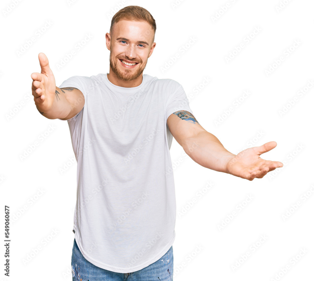 Young irish man wearing casual clothes looking at the camera smiling with open arms for hug. cheerful expression embracing happiness. Young irish man wearing casual clothes looking at the camera smiling with open arms for hug. cheerful expression embracing happiness.