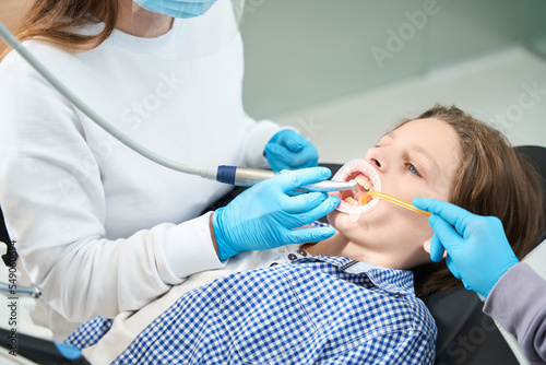 Young patient treats tooth at a dentist in medical institution