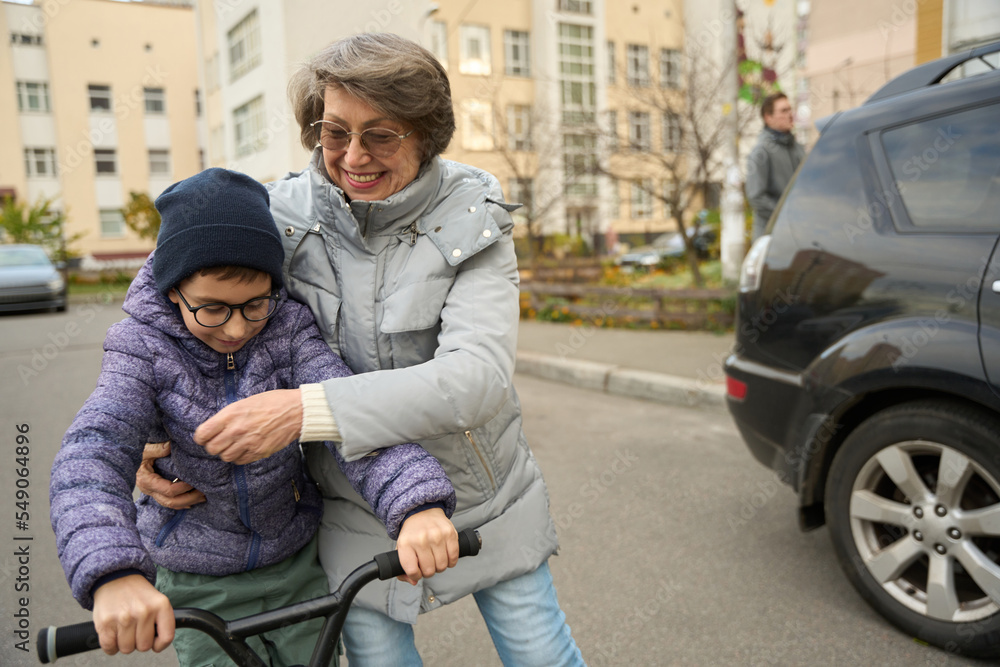 Child and grandmother walking down the street Child and grandmother walking down the street