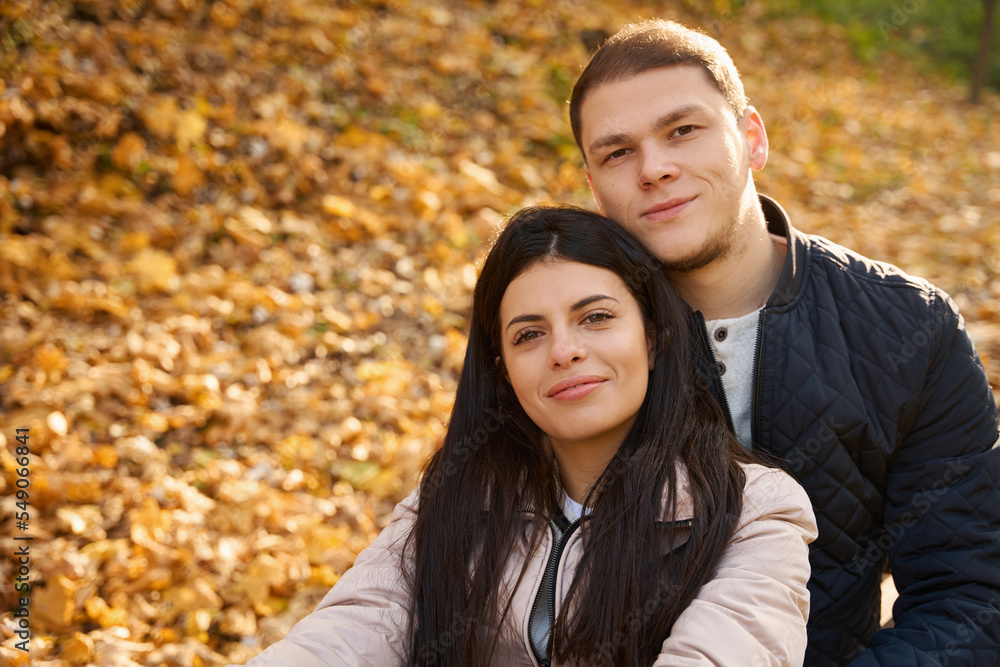 Pleasant couple is resting among the fallen yellow leaves Pleasant couple is resting among the fallen yellow leaves