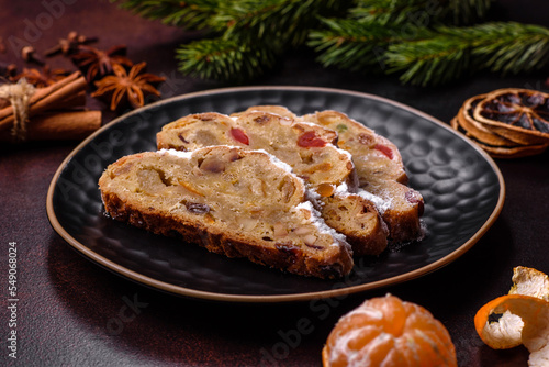Christmas pie stollen with marzipan  berries and nuts on a dark concrete background