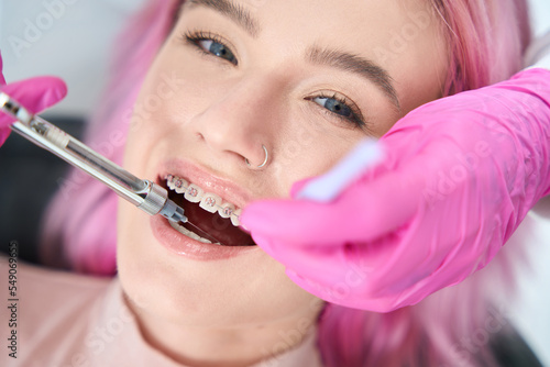 Woman with braces is given injection of anesthesia in gum