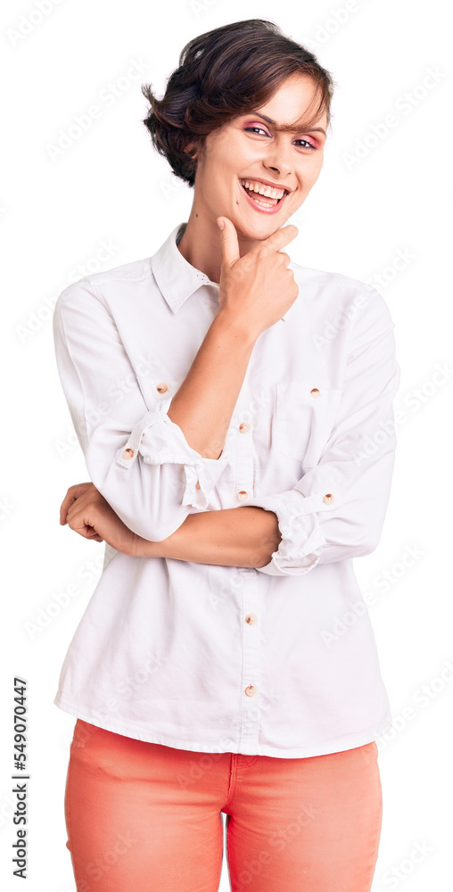 Beautiful young woman with short hair wearing elegant white shirt looking confident at the camera smiling with crossed arms and hand raised on chin. thinking positive. Beautiful young woman with short hair wearing elegant white shirt looking confident at the camera smiling with crossed arms and hand raised on chin. thinking positive.