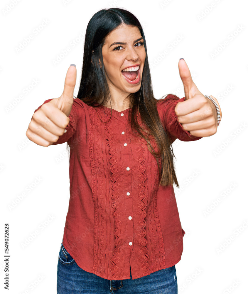 Young hispanic woman wearing casual clothes approving doing positive gesture with hand, thumbs up smiling and happy for success. winner gesture. Young hispanic woman wearing casual clothes approving doing positive gesture with hand, thumbs up smiling and happy for success. winner gesture.