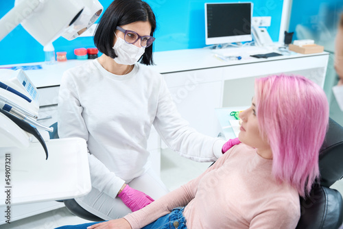 Young woman with pink hair at the dentist appointment