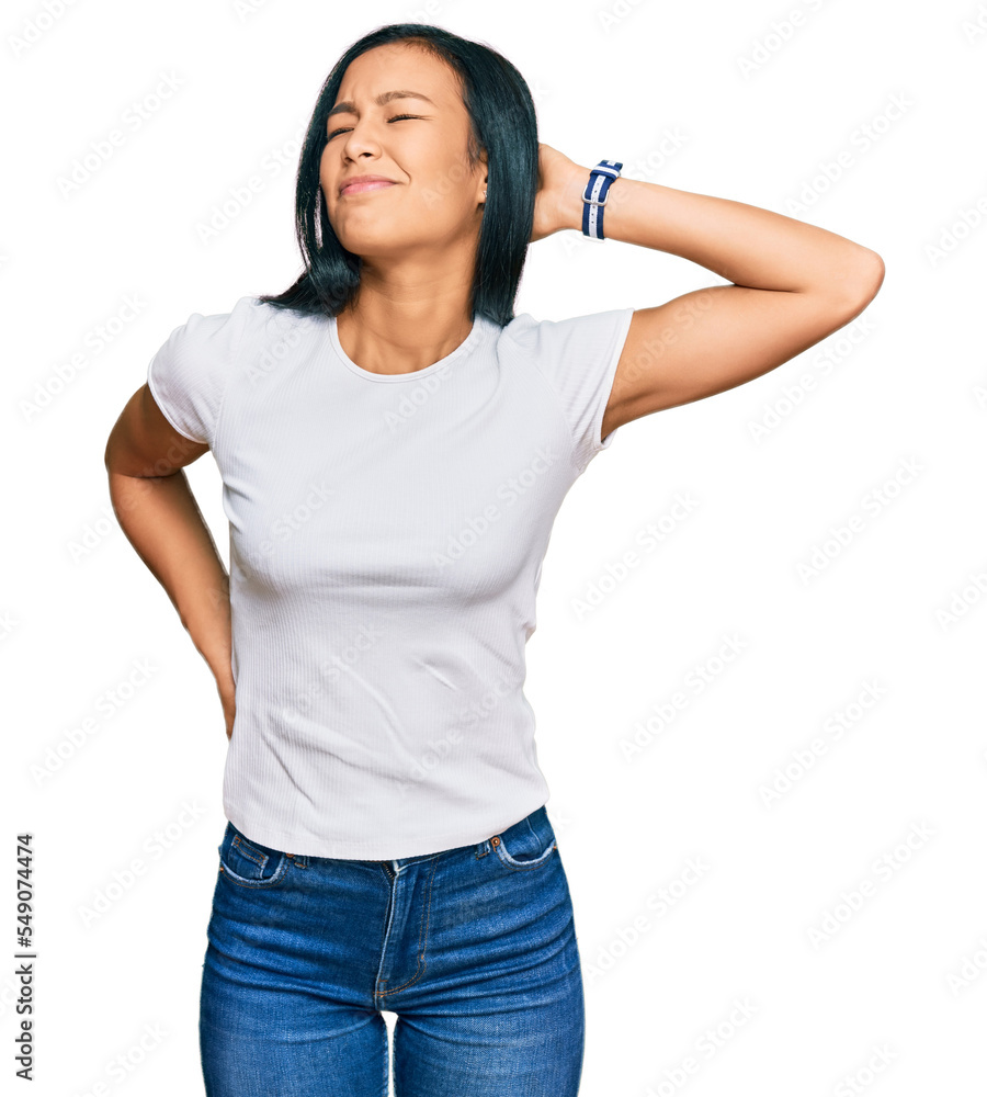 Beautiful hispanic woman wearing casual white tshirt suffering of neck ache injury, touching neck with hand, muscular pain Beautiful hispanic woman wearing casual white tshirt suffering of neck ache injury, touching neck with hand, muscular pain