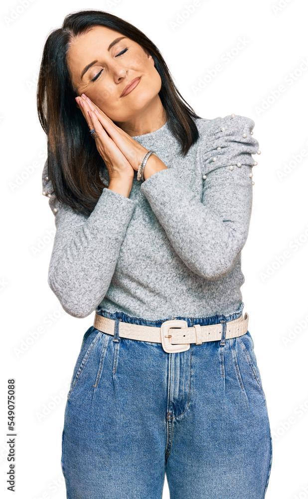 Middle age brunette woman wearing casual clothes sleeping tired dreaming and posing with hands together while smiling with closed eyes. Middle age brunette woman wearing casual clothes sleeping tired dreaming and posing with hands together while smiling with closed eyes.