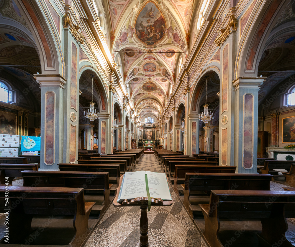 Fototapeta premium Boves, Italy - November 22, 2022: interior with frescoed vaults of parish church of san Bartolomeo with missal liturgical book in foreground
