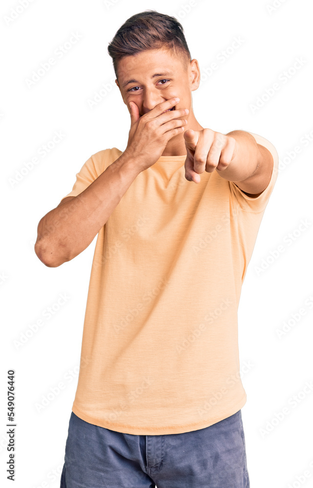 Young handsome man wearing casual clothes laughing at you, pointing finger to the camera with hand over mouth, shame expression Young handsome man wearing casual clothes laughing at you, pointing finger to the camera with hand over mouth, shame expression