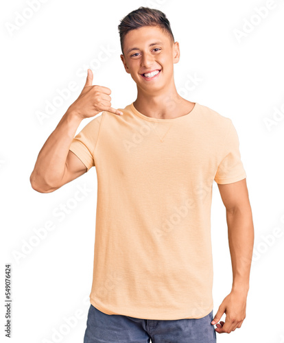 Young handsome man wearing casual clothes smiling doing phone gesture with hand and fingers like talking on the telephone. communicating concepts.