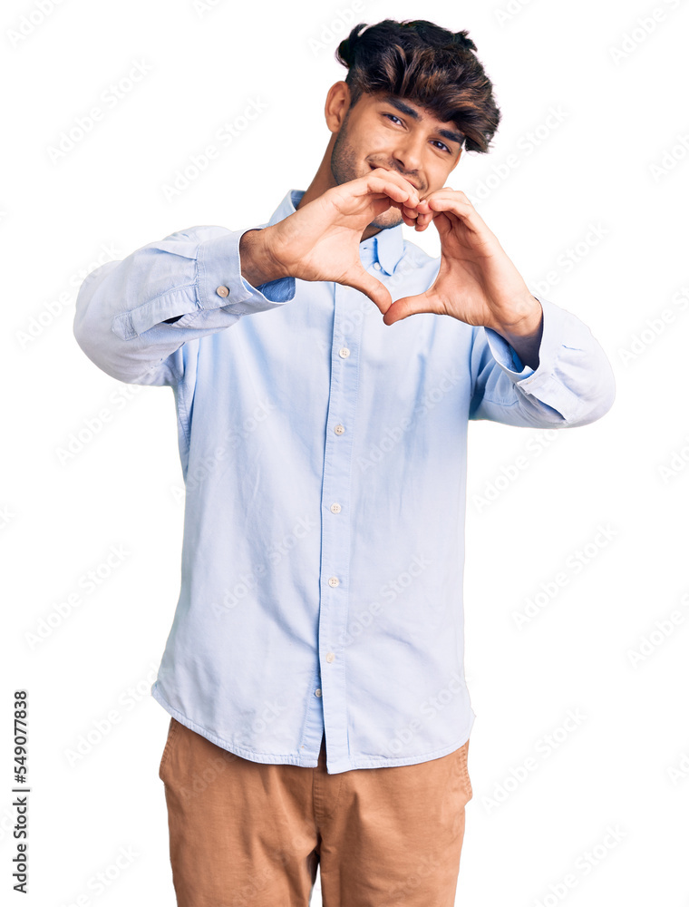 Young hispanic man wearing casual shirt smiling in love doing heart symbol shape with hands. romantic concept. Young hispanic man wearing casual shirt smiling in love doing heart symbol shape with hands. romantic concept.