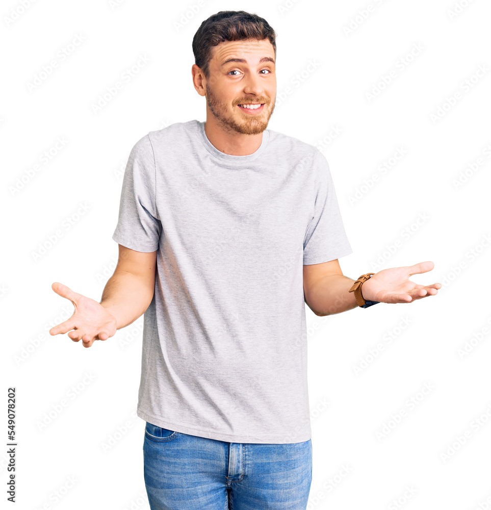 Handsome young man with bear wearing casual tshirt clueless and confused expression with arms and hands raised. doubt concept. Handsome young man with bear wearing casual tshirt clueless and confused expression with arms and hands raised. doubt concept.