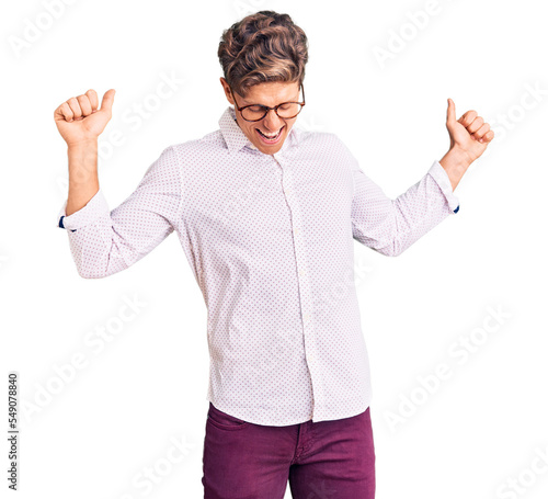 Young handsome man wearing business clothes and glasses dancing happy and cheerful, smiling moving casual and confident listening to music