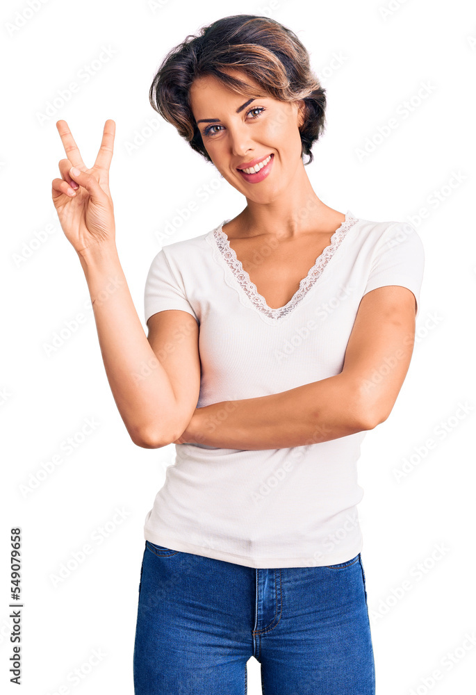 Young beautiful woman wearing casual clothes smiling with happy face winking at the camera doing victory sign. number two. Young beautiful woman wearing casual clothes smiling with happy face winking at the camera doing victory sign. number two.