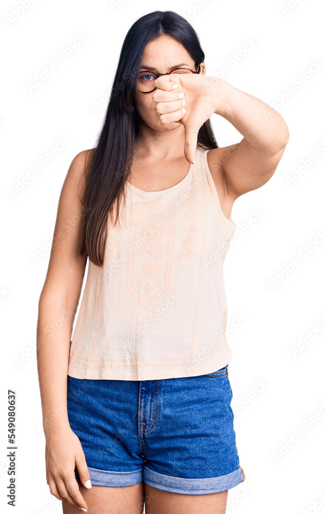 Young beautiful caucasian woman wearing casual clothes and glasses looking unhappy and angry showing rejection and negative with thumbs down gesture. bad expression. Young beautiful caucasian woman wearing casual clothes and glasses looking unhappy and angry showing rejection and negative with thumbs down gesture. bad expression.