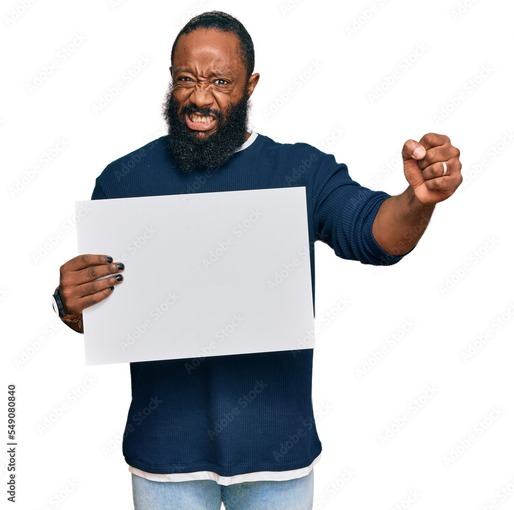 Young african american man holding blank empty banner annoyed and frustrated shouting with anger, yelling crazy with anger and hand raised Young african american man holding blank empty banner annoyed and frustrated shouting with anger, yelling crazy with anger and hand raised