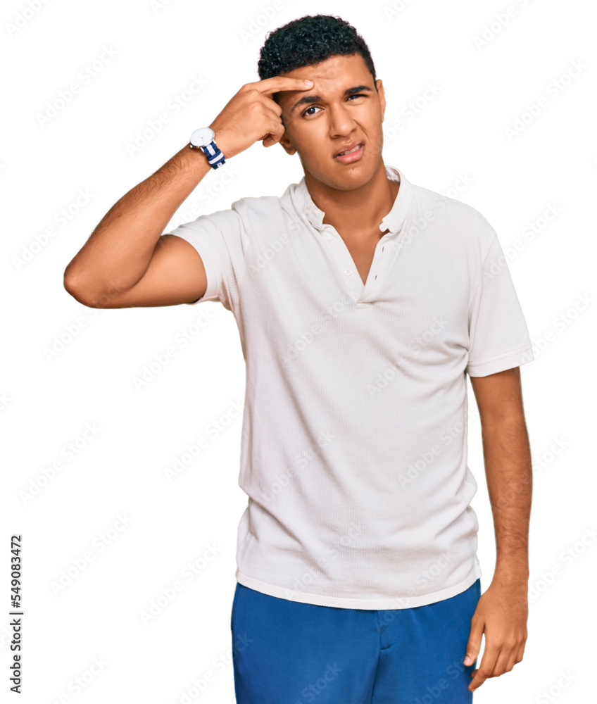 Fototapeta premium Young arab man wearing casual clothes pointing unhappy to pimple on forehead, ugly infection of blackhead. acne and skin problem