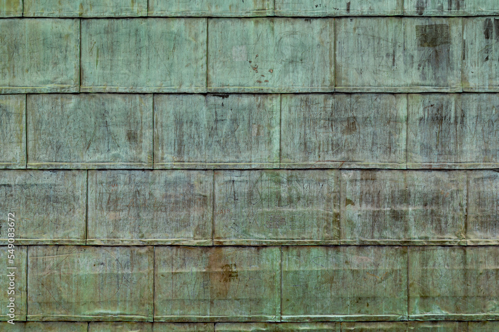 Oxidized copper folded sheet metal on roof. Copper wall texture background with marks and scrawls. Oxidized copper folded sheet metal on roof. Copper wall texture background with marks and scrawls.