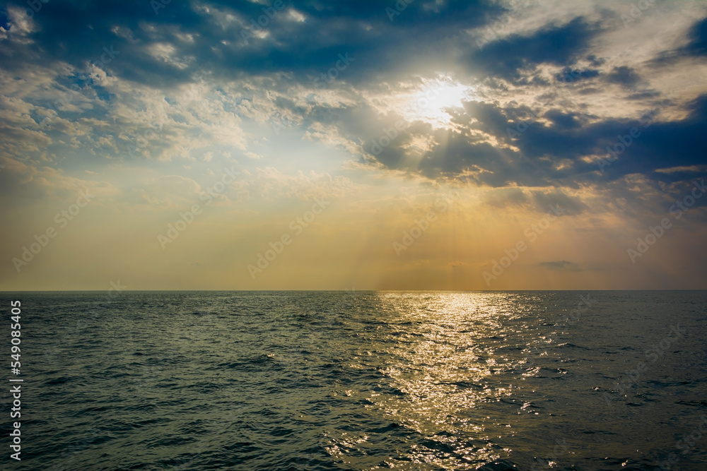 Obraz premium Dramatic sunset over water with beautiful light
