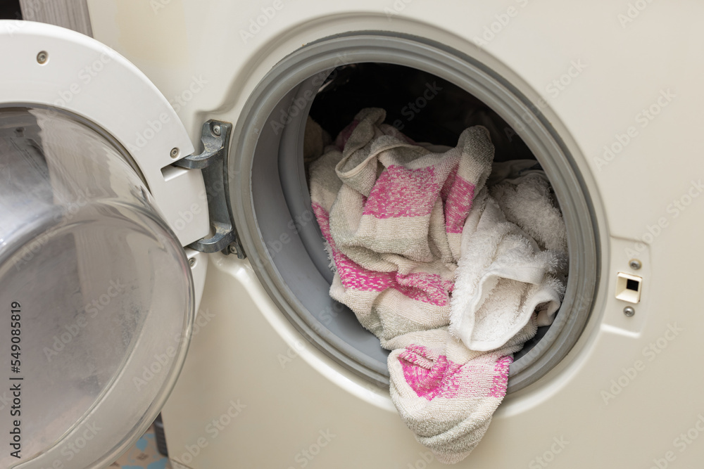 Clothes sticking out of the washing machine. Clothes sticking out of the washing machine.