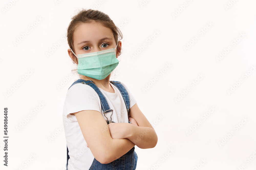 Adorable little girl in protective mask, isolated on white. Virus symptoms. Concept of air pollution, epidemic, influenza, protection from disease. Flu illness. Pediatrics. Medical care. Insurance. Adorable little girl in protective mask, isolated on white. Virus symptoms. Concept of air pollution, epidemic, influenza, protection from disease. Flu illness. Pediatrics. Medical care. Insurance.