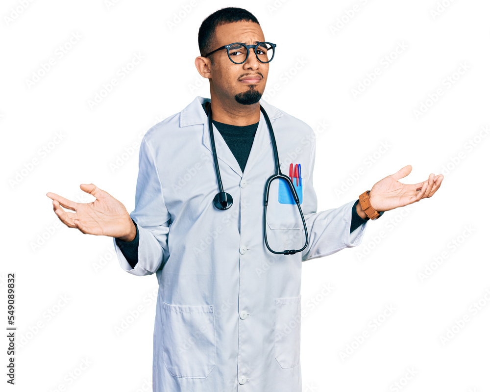 Young african american man wearing doctor uniform and stethoscope clueless and confused with open arms, no idea concept. Young african american man wearing doctor uniform and stethoscope clueless and confused with open arms, no idea concept.