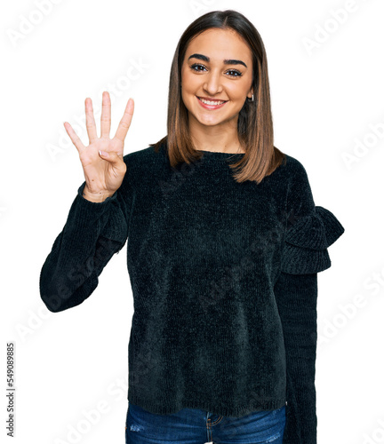 Beautiful brunette woman wearing elegant sweater showing and pointing up with fingers number four while smiling confident and happy.