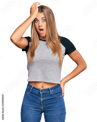 Young blonde woman wearing casual clothes surprised with hand on head for mistake, remember error. forgot, bad memory concept.