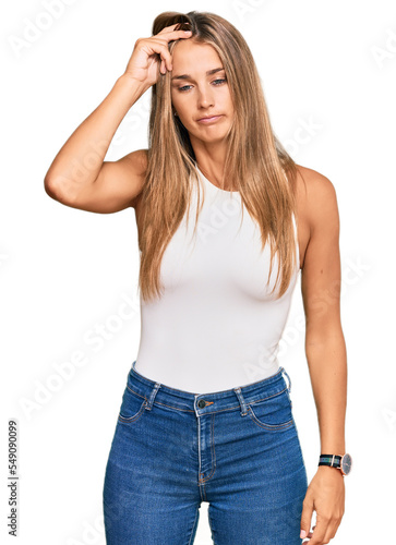 Young blonde woman wearing casual style with sleeveless shirt worried and stressed about a problem with hand on forehead, nervous and anxious for crisis