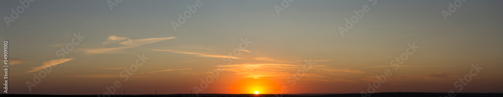 Fototapeta premium Panorama. Landscape with dawn. The sun rises through light cirrus clouds.