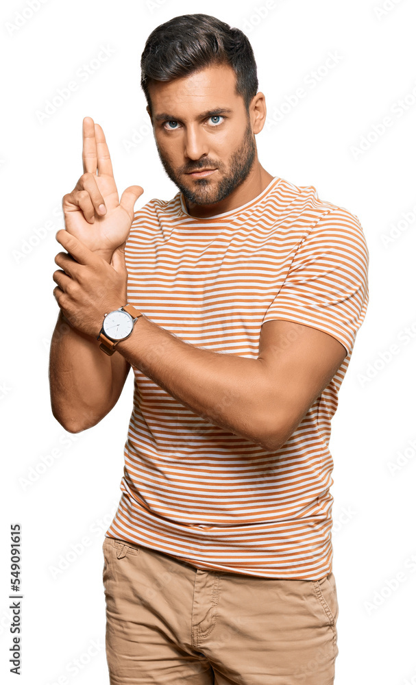 Handsome hispanic man wearing casual clothes holding symbolic gun with hand gesture, playing killing shooting weapons, angry face Handsome hispanic man wearing casual clothes holding symbolic gun with hand gesture, playing killing shooting weapons, angry face